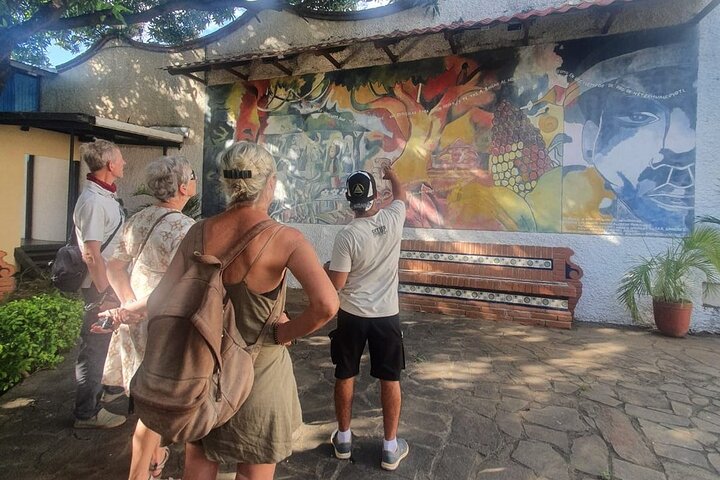 Our tour guide explaining a mural in Leon